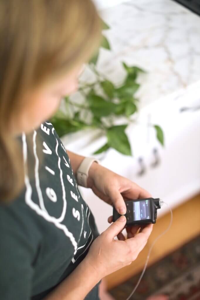 Jess adjusting her insulin pump, the lived experience behind her work as a health and wellness website designer