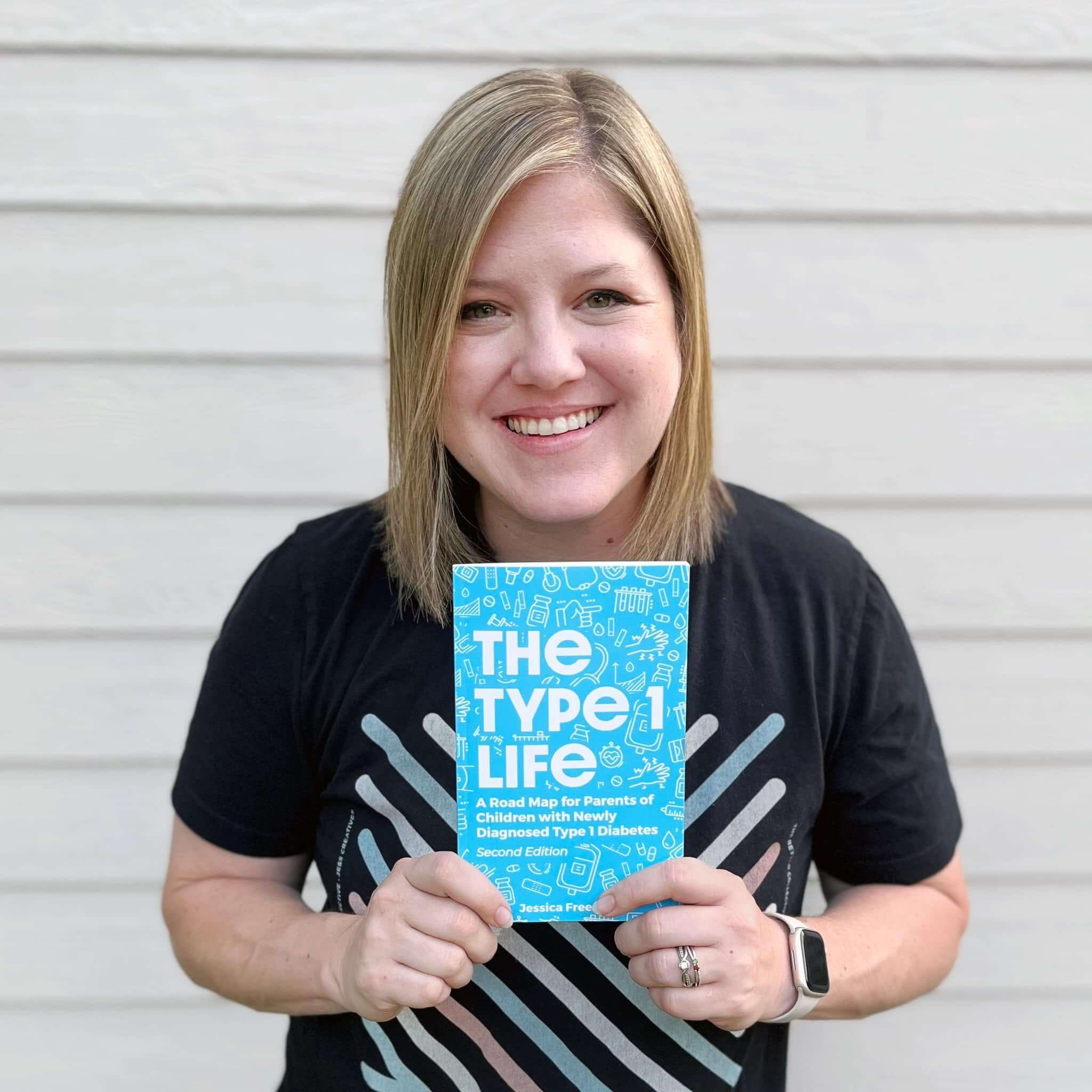 Jess Freeman holding her book The Type 1 Life, written by the health and wellness website designer behind Jess Creatives